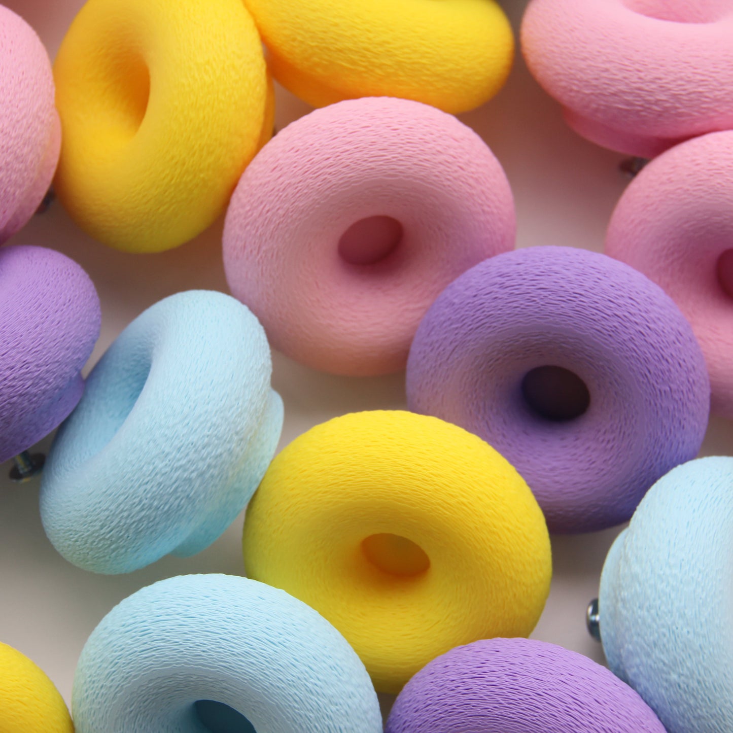 hoto studio zoomé sur boutons de meubles donuts montrant différentes couleurs personnalisable (couleurs rose, jaune, ice blue, lilac purple)