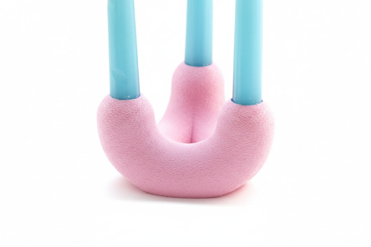 Gros plan sur le bougeoir TriU rose et ses trois chandelles bleu clair