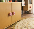 présentation de 2 boutons de meuble donuts rose sur meuble de salon moderne et design