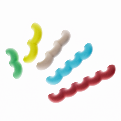Une collection de cinq poignées de meubles ondulées en biopolymère, disposées en diagonale sur un fond blanc uni. Chaque poignée a une texture mate et grenue et varie en longueur. Les couleurs sont, de gauche à droite : vert, jaune citron, beige clair, bleu ciel et rouge.