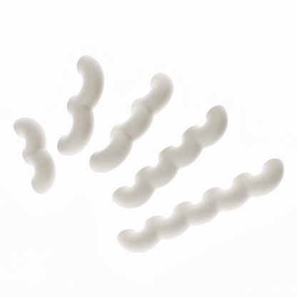 Une vue de présentation de cinq poignées de meubles ondulées en beige, disposées en diagonale par ordre de taille croissant sur un fond blanc pur. Cette image illustre clairement les cinq différentes longueurs disponibles dans la collection. Leur texture est mate et légèrement granuleuse, typique du biopolymère.
