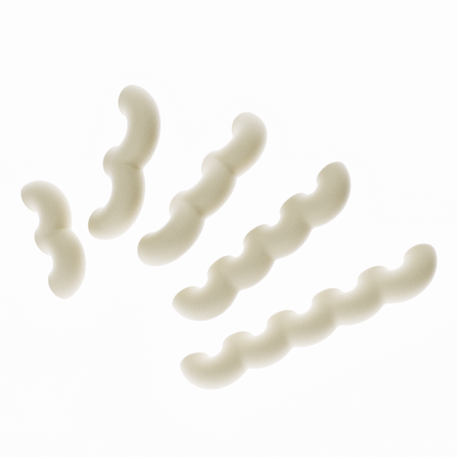 Une vue de présentation de cinq poignées de meubles ondulées en desert tan, disposées en diagonale par ordre de taille croissant sur un fond blanc pur. Cette image illustre clairement les cinq différentes longueurs disponibles dans la collection. Leur texture est mate et légèrement granuleuse, typique du biopolymère.
