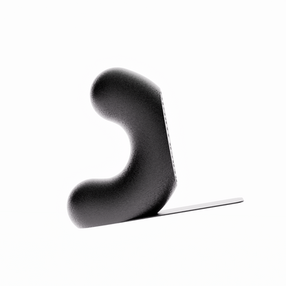 Un serre-livre design de la marque Benga Studio, de couleur noir. L'objet moderne a une forme de U stylisé, avec une hauteur de 15 cm. Il est présenté sur un fond blanc pur, avec une languette de support  mince et horizontal s'étendant à droite pour supporter des grands livres. Le serre-livre a une texture fine, lisse et mate. Il est conçu pour maintenir des livres lourds de manière discrète et élégante.