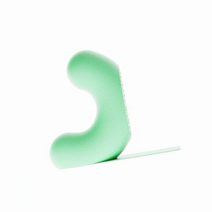 Un serre-livre design de la marque Benga Studio, de couleur vert clair mat. L'objet moderne a une forme de U stylisé, avec une hauteur de 15 cm. Il est présenté sur un fond blanc pur, avec une languette de support  mince et horizontal s'étendant à droite pour supporter des grands livres. Le serre-livre a une texture fine, lisse et mate. Il est conçu pour maintenir des livres lourds de manière discrète et élégante.